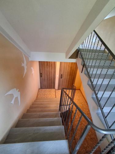 a staircase in a house with a glass railing at Apartamentai Ventėje in Ventė