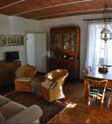 a living room with a table and chairs and a couch at Cascina Coccione in Predosa