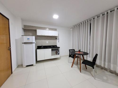 a kitchen with a table and chairs and a kitchen with a stove at Amazing Flat in João Pessoa in João Pessoa