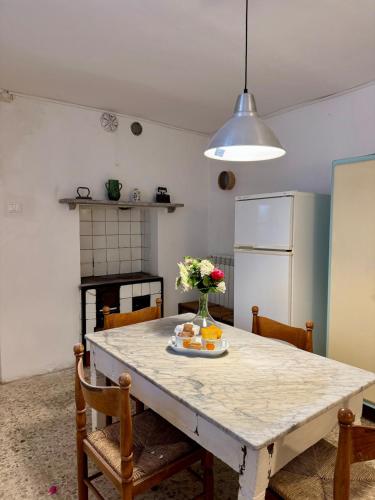 a kitchen with a table with a vase of flowers on it at Cascina Coccione in Predosa