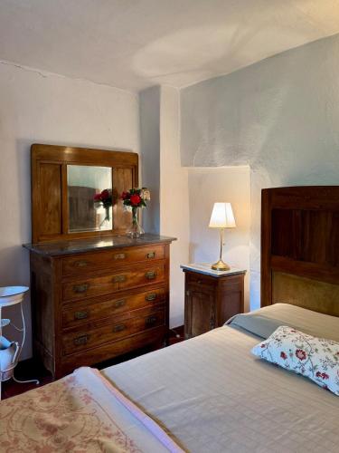 a bedroom with a bed and a dresser with a mirror at Cascina Coccione in Predosa