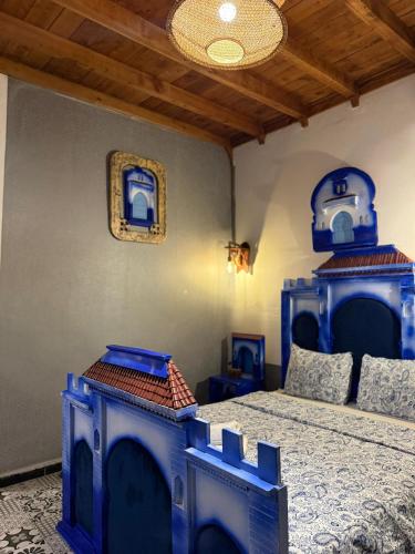 a bedroom with two blue beds in a room at Auberge Alwahabi in Chefchaouene