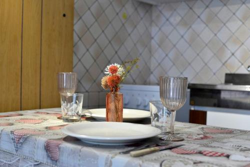 a table with a plate and two wine glasses at Monolocale sulle piste in Champsil