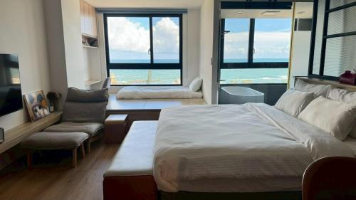 a bedroom with a bed and a couch and a chair at La Vie - Ocean Paradise in Toucheng