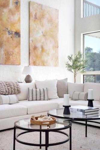 a living room with a white couch and two tables at Majestic Oak - Luxury, Billiards Room & Pool in San Antonio