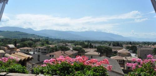 a city with mountains in the background and pink flowers at Spello House Altana in Spello