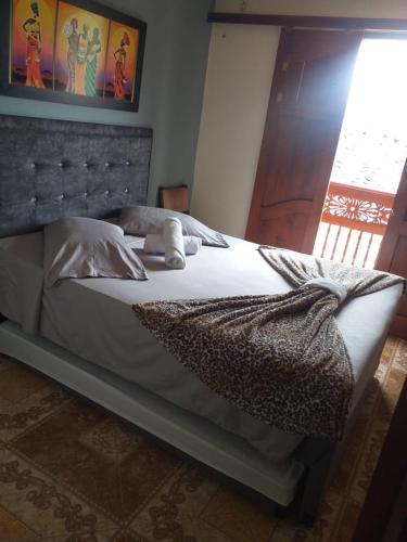 a bedroom with a large bed with white sheets at HOSTAL LA CASA DE LOS SUEÑOS in Jardin