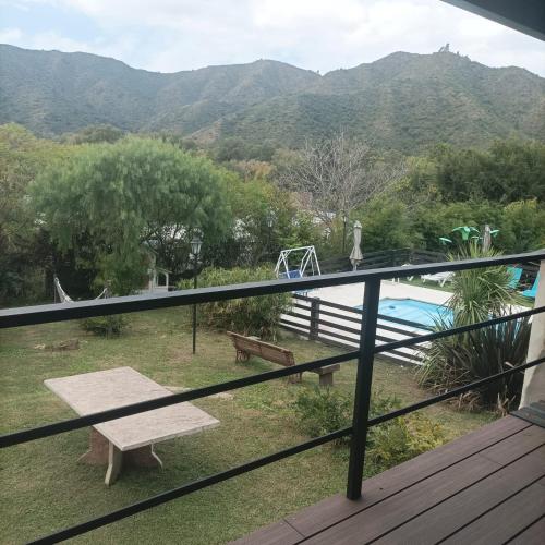 a balcony with a view of a pool and mountains at Cabañas Noscohue in Villa General Belgrano