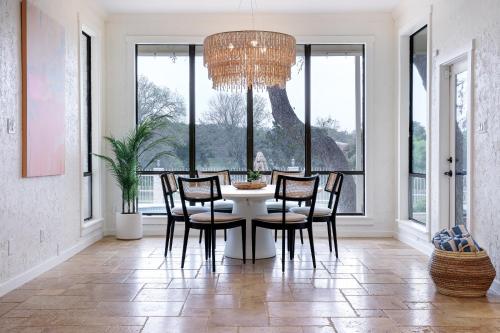 a dining room with a table and chairs and a chandelier at Majestic Oak - Luxury, Billiards Room & Pool in San Antonio