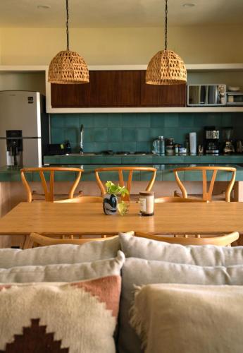 a dining room with a table and chairs and a kitchen at Ocean View 2 Bedroom Apartment in Punta Cocos - A201 in Holbox Island