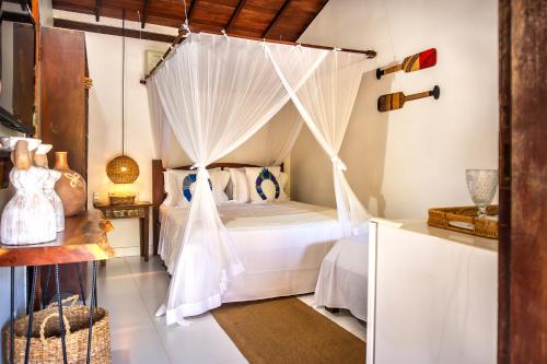 a bedroom with a bed with a mosquito net at Pousada Campestre in Trancoso