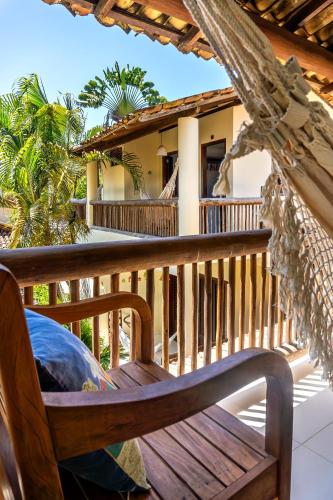 a wooden bench on a porch with a house at Pousada Campestre in Trancoso