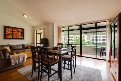a living room with a table and chairs and a couch at CR MARIPOSA RENTALS lakeview, spacious penthouse with office, pool, gym, Jacuzzi in Santa Ana