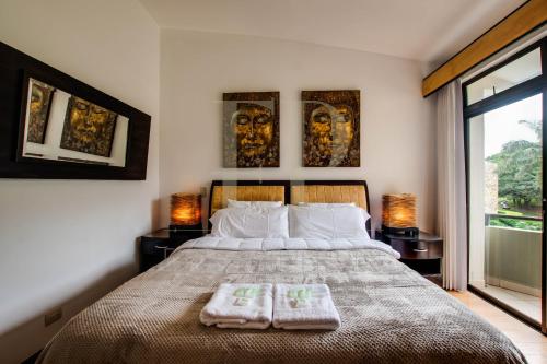 a bedroom with a bed with two towels on it at CR MARIPOSA RENTALS lakeview, spacious penthouse with office, pool, gym, Jacuzzi in Santa Ana