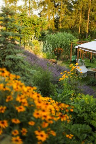 a garden with flowers and a gazebo at Czereśniowe Wzgórze Sandomierz jakuzzi in Sandomierz