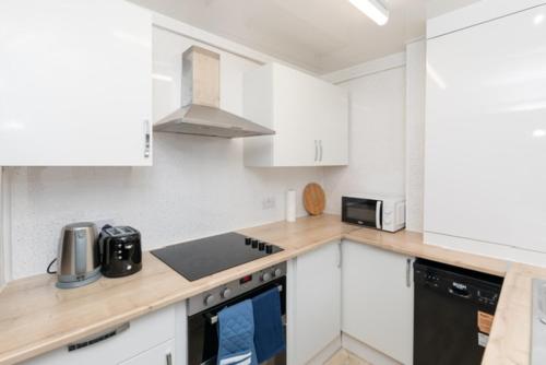 a kitchen with white cabinets and a counter top at Charming 2-bedroom house in Hartlepool
