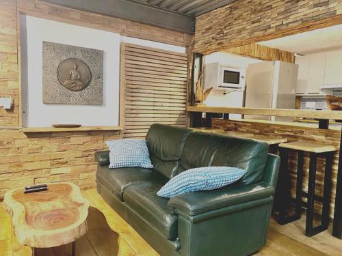 - un salon avec un canapé en cuir vert et une table dans l'établissement Coccon Malmousque, à Marseille