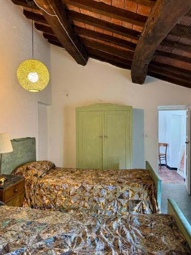 a bedroom with two beds and a green cabinet at Cascina Coccione in Predosa