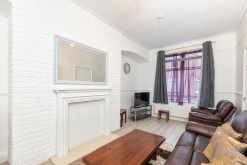 a living room with a couch and a fireplace at Charming 2-bedroom house in Hartlepool