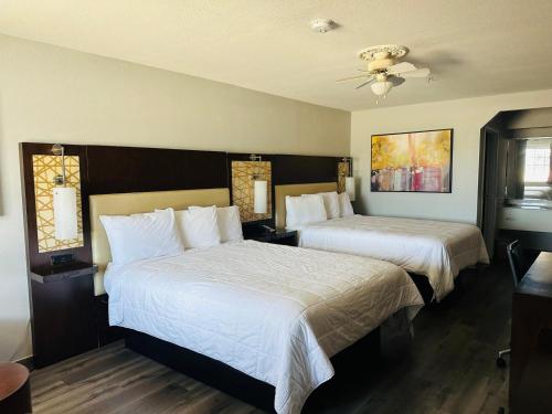 a hotel room with two beds and a ceiling at Executive Inn & Suites West Columbia in West Columbia