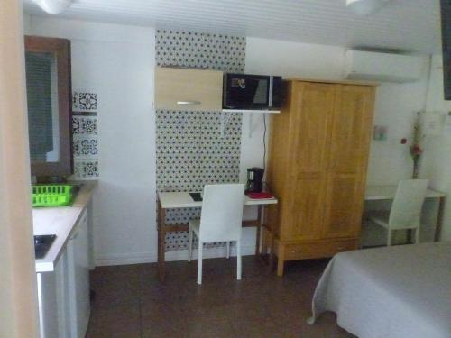 a small kitchen with a table and chairs in a room at Au Petit Canal Fleuri in Rémiré