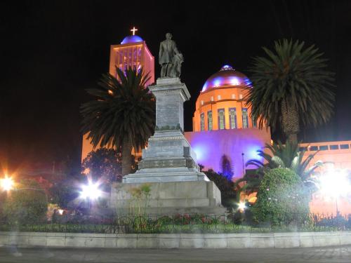 a statue in front of a building at night at Roka Plaza Hotel Boutique in Ambato