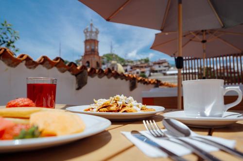 a table with plates of food and a cup of tea at Hotel Casa Kavia Vallarta in Puerto Vallarta