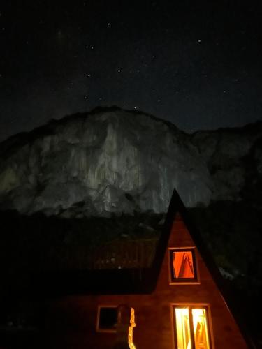 a night view of a cabin with a light in the window at Komarnica Forest Owl in Šavnik