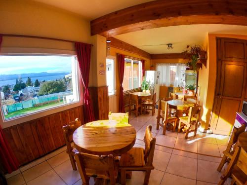 a dining room with a table and chairs and a window at Refugio Patagonia Hostel in San Carlos de Bariloche