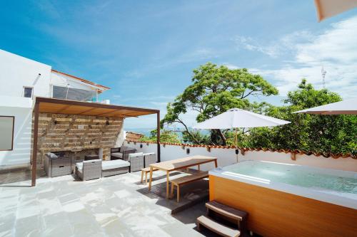 an outdoor patio with a table and a swimming pool at Hotel Casa Kavia Vallarta in Puerto Vallarta