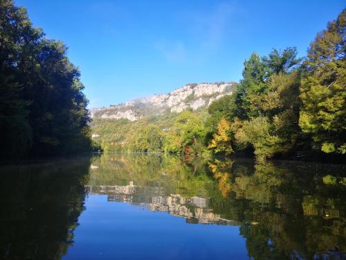 Montbrunにあるtente de trappeur au camping les cournoulises 2 à 4 personnesの木々と山を背景にした川