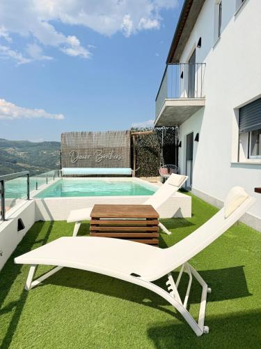 a patio with a lounge chair and a swimming pool at DOURO BROTHERS in Resende