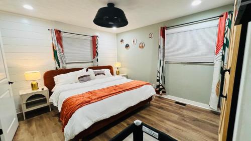 a bedroom with a large bed and two windows at indy dreamhouse lux stay in Greenwood