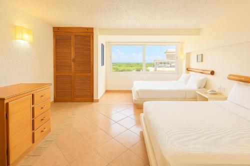 a hotel room with two beds and a window at Beach Front Condos in Hotel Zone in Cancún