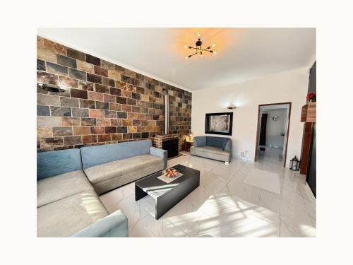 a living room with a couch and a brick wall at Rihla Residences - Civic Road in Cape Town