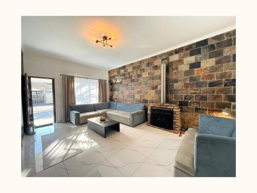 a living room with couches and a brick wall at Rihla Residences - Civic Road in Cape Town