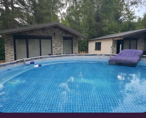 a large blue swimming pool with a purple lounger at Domki Solina Leśny Chillout in Solina