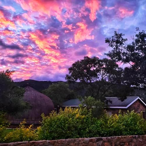 a sunset view from the backyard of a house at Olive Country Lodge - Eswatini in Ngwempisi