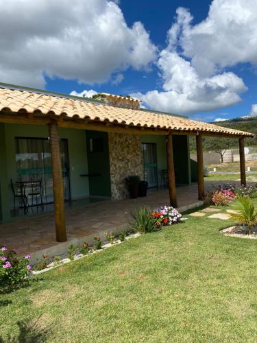 een huis met een patio met een dak bij Pousada Pé da Serra - São Thomé das Letras in São Thomé das Letras