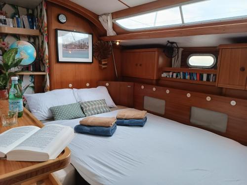 a bedroom with a bed and a table with a book at Voilier élégant et confortable 
