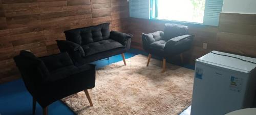 two chairs and a couch in a room at Cantinho da serra in Catas Altas