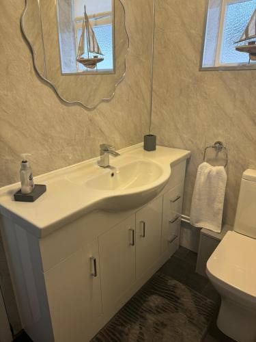 a bathroom with a sink and a mirror at Large 4 bedroom house in Heckington