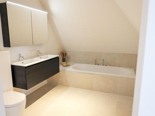 ein Badezimmer mit Badewanne, Waschbecken und Toilette in der Unterkunft IndigoBoathouse - Luxury Duplex Nieuwpoort Jachthaven in Nieuwpoort