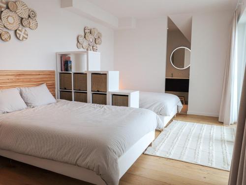 ein Schlafzimmer mit zwei Betten und einem Spiegel in der Unterkunft IndigoBoathouse - Luxury Duplex Nieuwpoort Jachthaven in Nieuwpoort