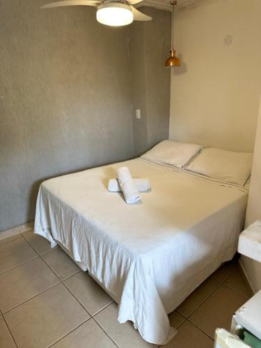 two beds in a room with two towels on the bed at Pousada Janellas do Mar in Búzios