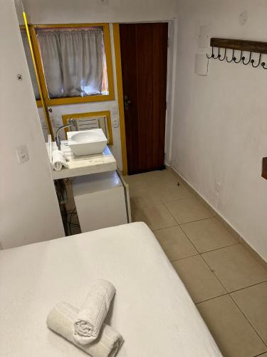 a bathroom with a sink and a towel on a counter at Pousada Janellas do Mar in Búzios