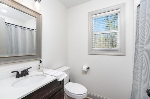 a white bathroom with a sink and a window at Pickleball - 2 Master Suites - Fire Pit - Game Rm in Nellysford