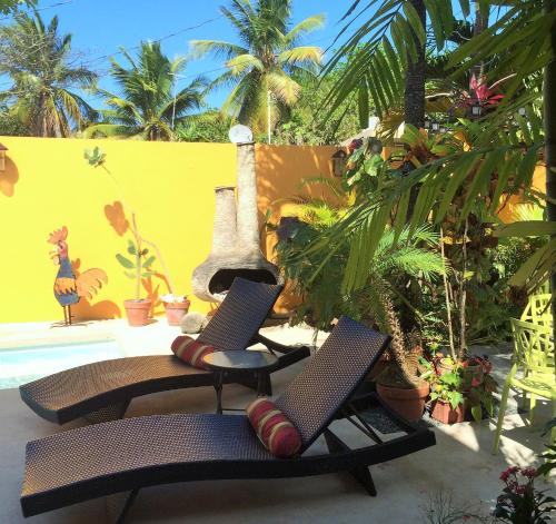 two chairs on a patio next to a pool at Casa de Amistad Guesthouse in Vieques