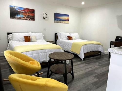 コーニングにあるGatehouse Motelのベッド2台とテーブルと椅子のある部屋