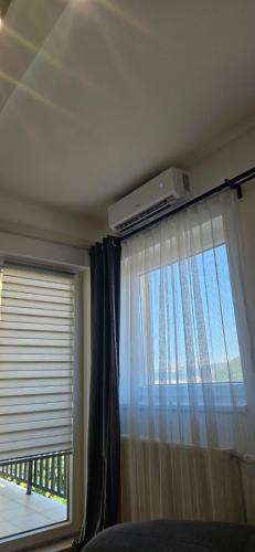 a bedroom with a window with a television on the ceiling at Golubica in Golubac